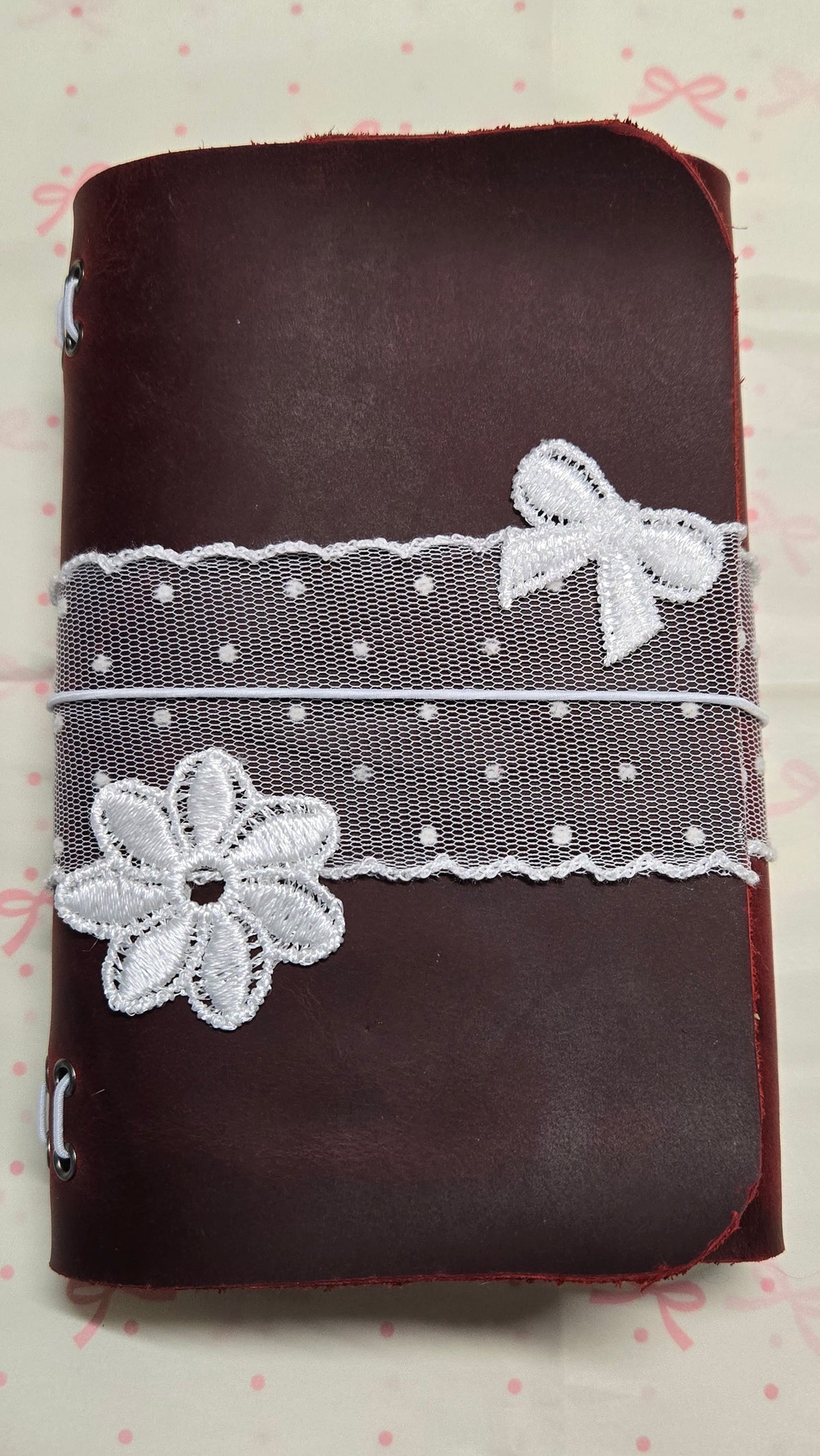 Burgundy leather MARIS journal customized with white lace, a bow, and a flower